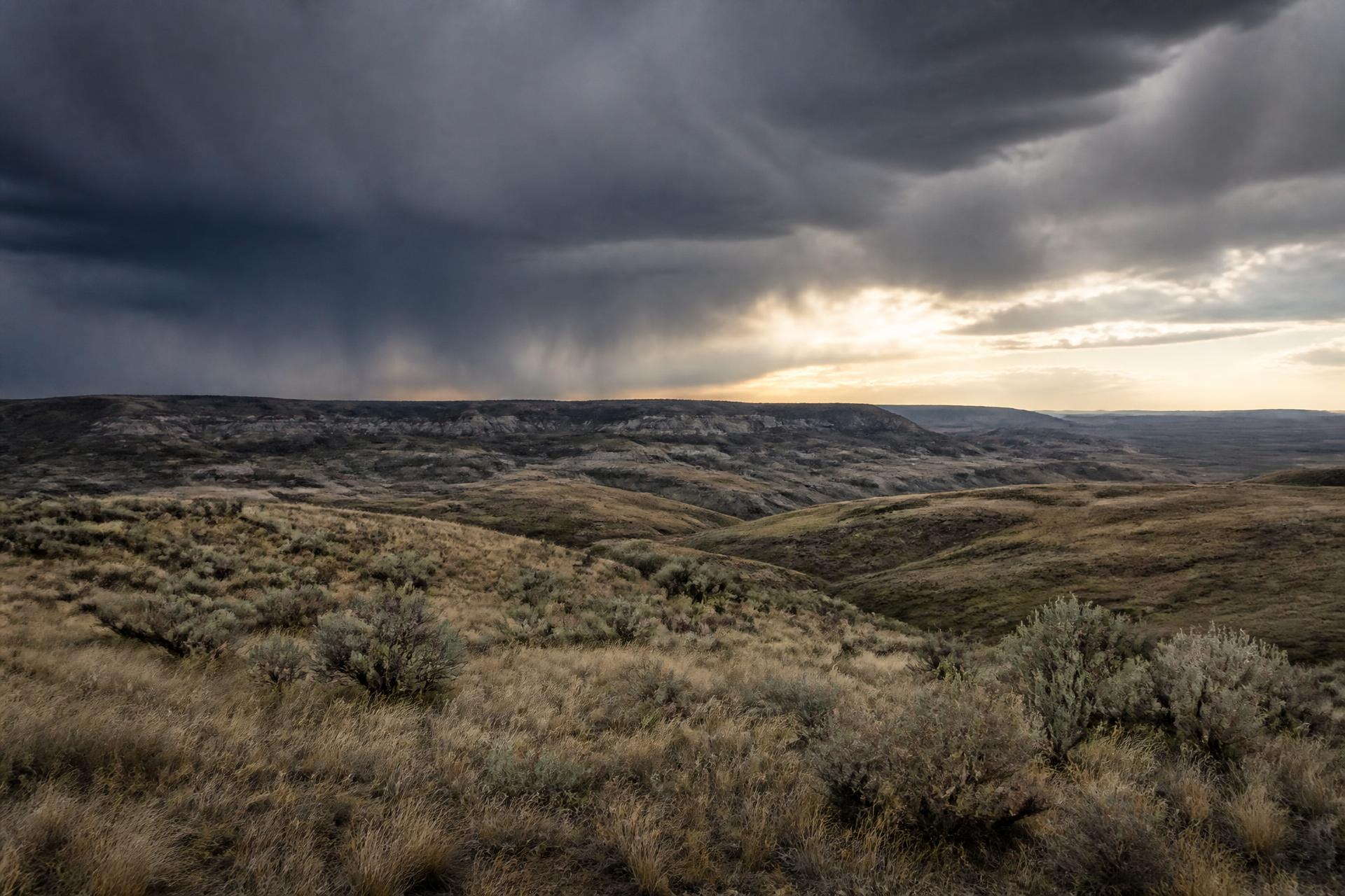 Sagebrush ridges and badland rims of the central Wyoming high plains under a storm front